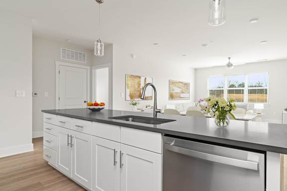 A modern kitchen with white cabinets and a black countertop.