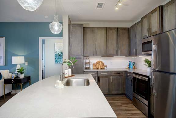 A modern kitchen with a large island and stainless steel appliances.