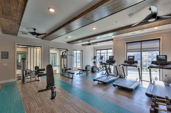 A gym with treadmills, weights, and exercise equipment.
