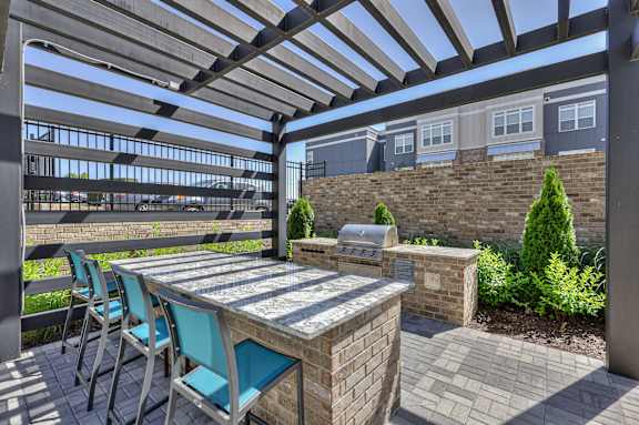 A patio with a table and chairs under a pergola.