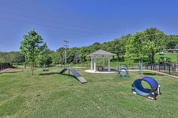 A playground with a slide, swings, and a seesaw.