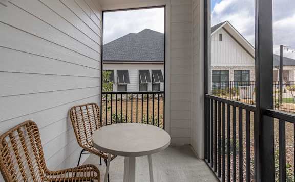 A balcony with a round table and two chairs.