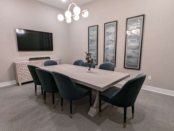 A dining room with a large table and chairs.