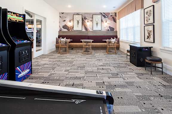 A room with a carpeted floor and a pool table.