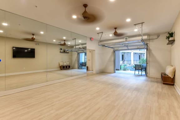 an empty room with a large mirror and a projection screen on the wall
