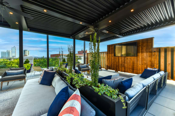 a roof deck with couches and a tv