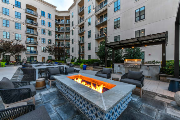 an outdoor patio with a fire pit and lounge chairs