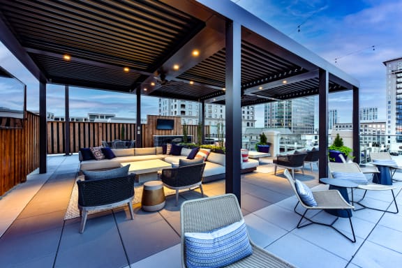 a roof top patio with lounge furniture and a fireplace