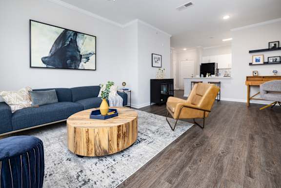 A living room with a blue couch and a wooden coffee table.