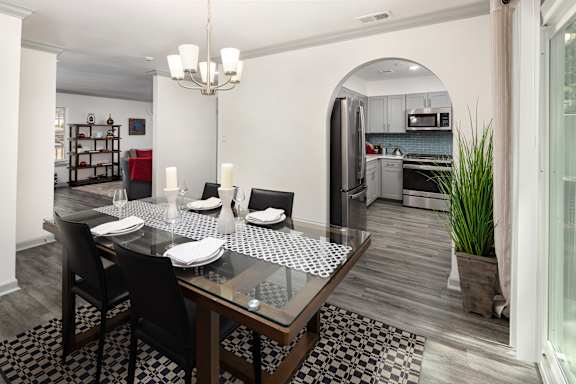A modern dining room with a glass table and chairs.