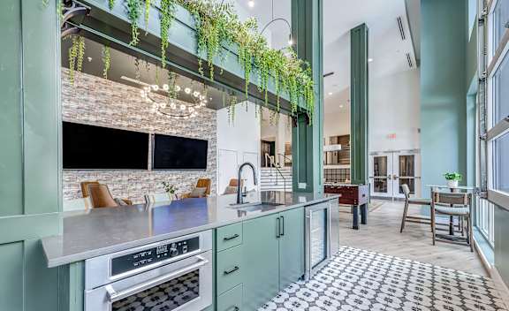 A kitchen with a green theme and a brick wall.
