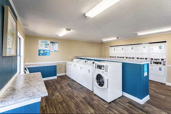 A laundromat with a row of washers and dryers.