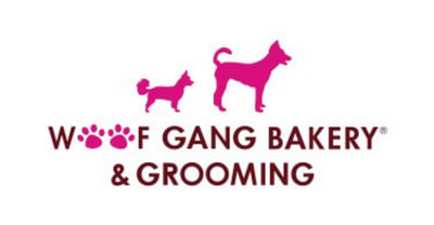 A logo for a bakery and grooming business featuring two pink dogs.