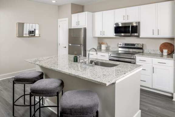 a kitchen with an island and stools at Fairview Springs in Covington, GA, 30016