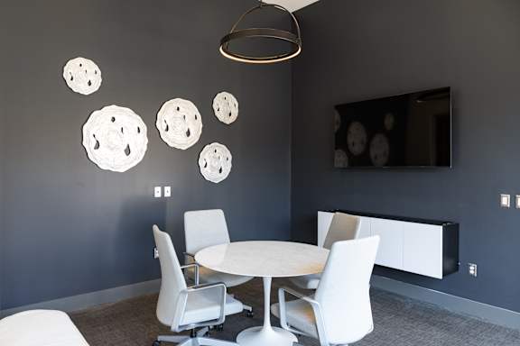 a room with a table and chairs and a television on the wall at Tower on Tenth Apartments, Birmingham