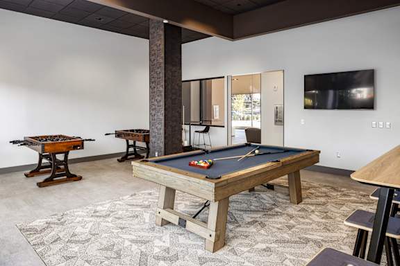 a games room with a pool table and a foosball table at Tower on Tenth Apartments, Birmingham, AL