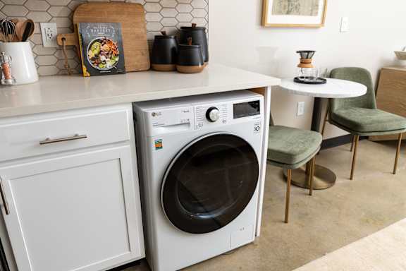 a white washer and dryer in a kitchen with white cabinets and a white counter top at Tower on Tenth Apartments, Birmingham, AL, 35205