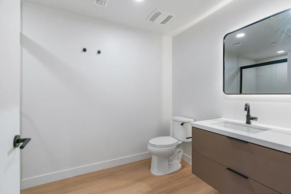 A white toilet sits next to a sink in a small bathroom.