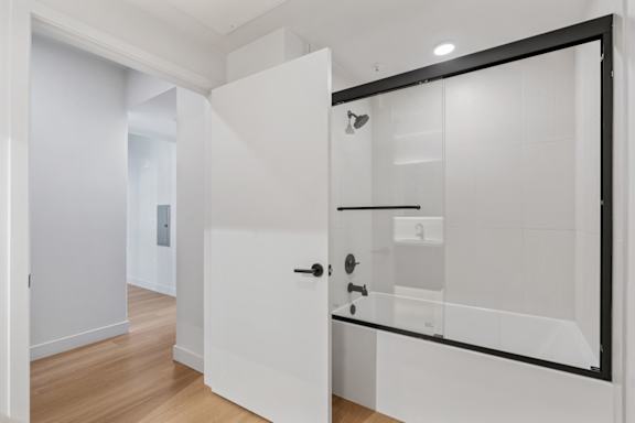 A white bathroom with a glass shower door.