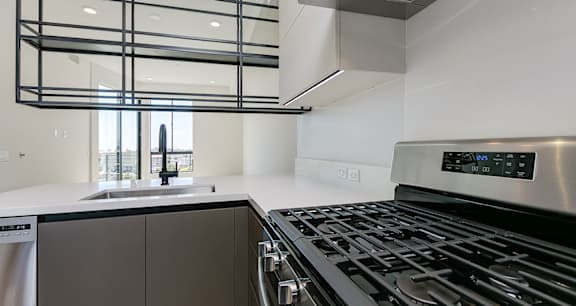 Suspended metal shelves as a divider between the kitchen and living space