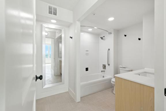 A white bathroom with a tub, toilet, and sink.