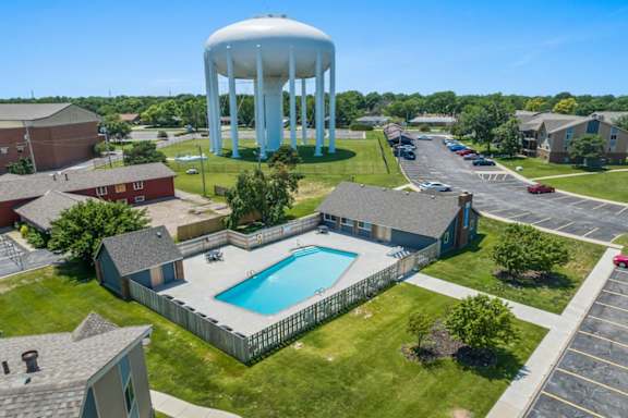 an aerial view of a pool and water tower in a neighborhood