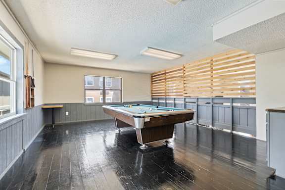 a game room with a pool table and windows