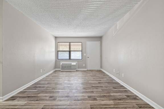 the spacious living room of an empty house with a window