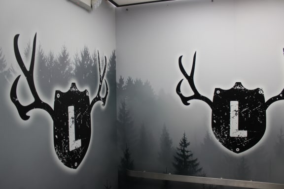 two deer logos on a wall with a forest in the background at The Lodge Apartments, Tulsa, 74129