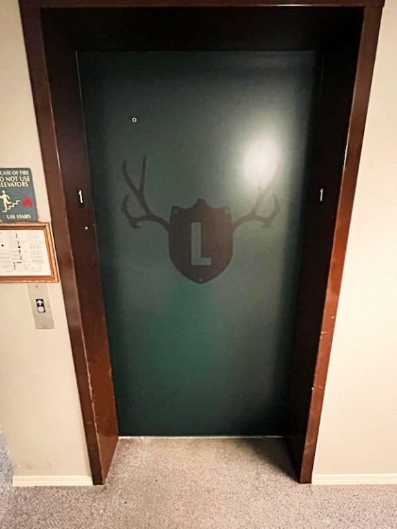a door with a deer head and the letter l on it at The Lodge Apartments, Oklahoma, 74129