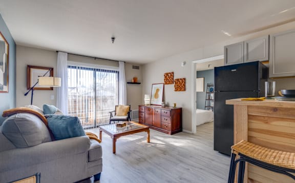 a living room with a couch and a table and a refrigerator