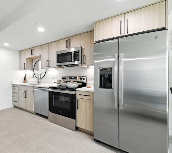 A modern kitchen with stainless steel appliances and wooden cabinets.
