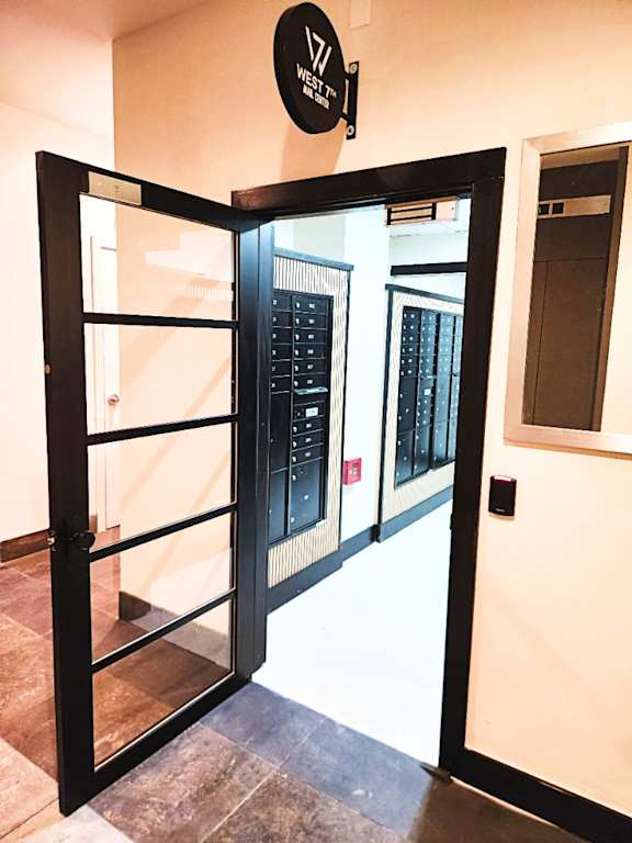 A black door with a glass window and a sign above it that says