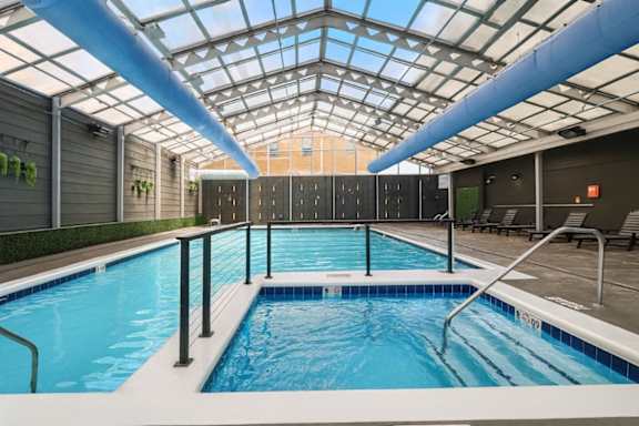 A large indoor swimming pool with a skylight above it.