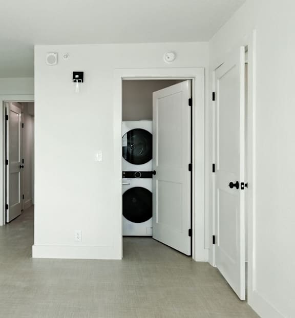 A white door is open to a laundry room.