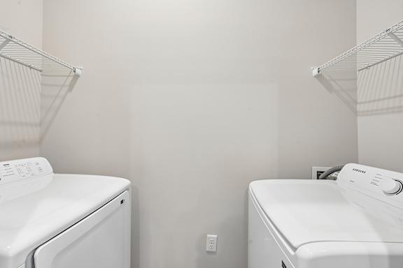 Two white front load washing machines in a laundry room.