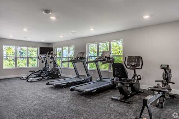A spacious gym with treadmills and elliptical machines.