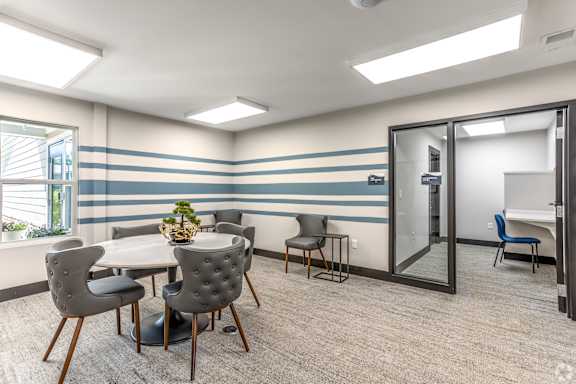 A conference room with a table, chairs, and a plant.