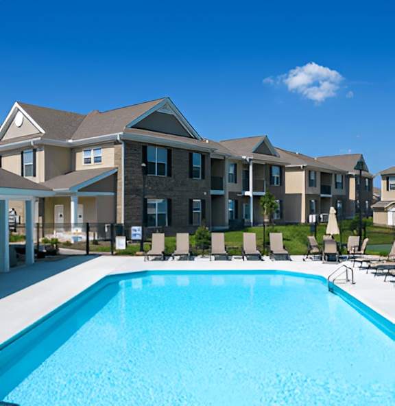 A swimming pool in front of a building with a clear blue sky.