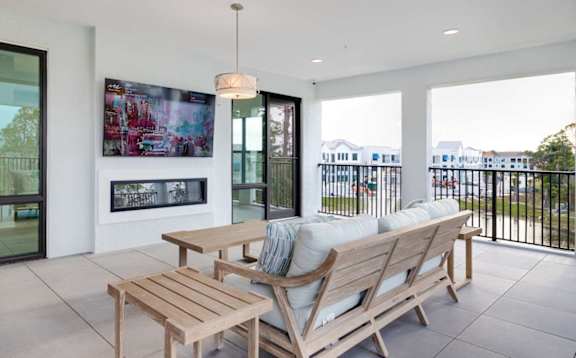 A modern balcony with a table and chairs overlooking a cityscape.