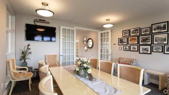 A dining room with a long table and chairs.