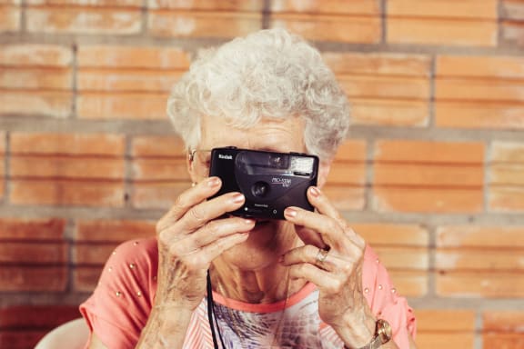 Woman Taking Photo at Rancho Franciscan Senior Apartments, Santa Barbara