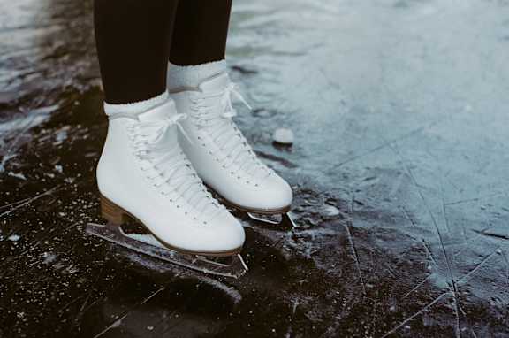 a girl in white boots on a skateboard