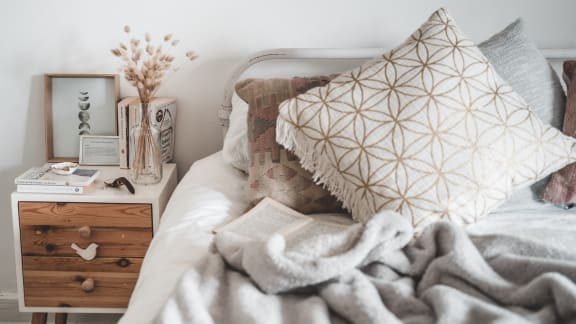 a bedroom with a bedside table with a book and a pillow
