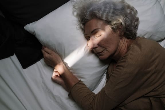 a woman laying in bed with her head on a pillow