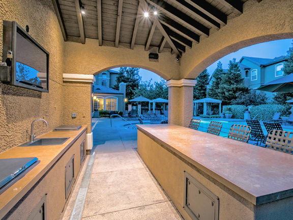 Covered Outdoor Kitchen and Bar at Night with Lighting at Fairfield CA Apartment