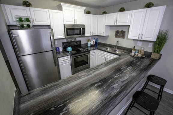 long granite style countertop in kitchen with stainless steel appliances