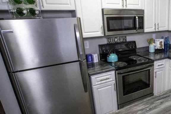 stainless steel fridge, oven, and built-in microwave in kitchen