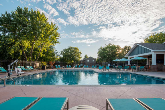 a swimming pool with lounge chairs and umbrellas