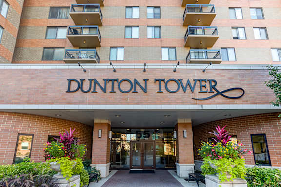 The Dunton Tower building has a red brick facade and a sign above the entrance.